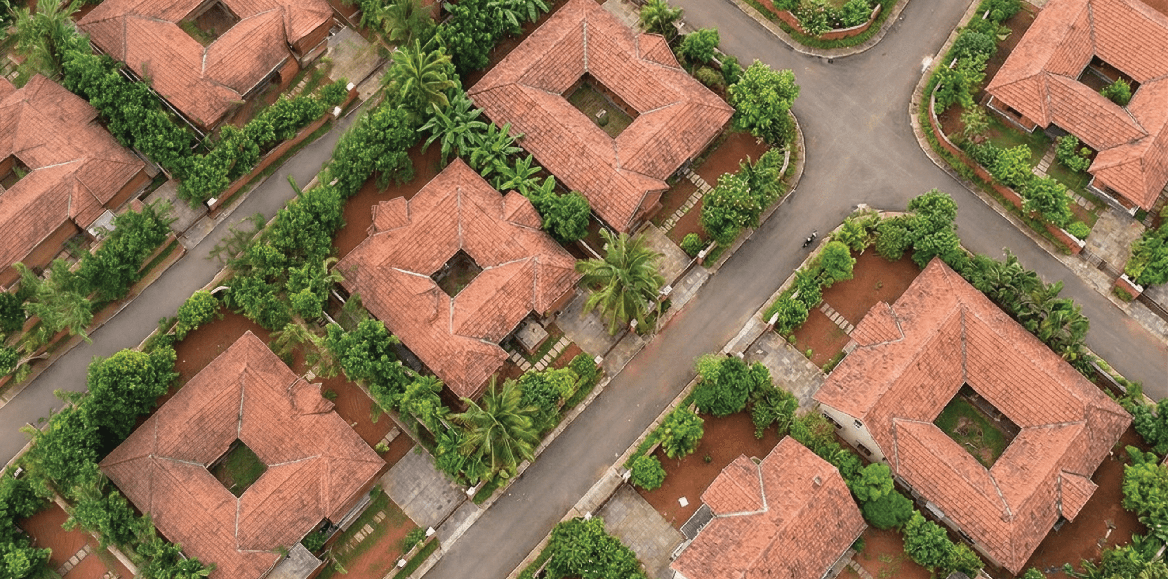 Aerial view of Nava Manchanballe premium plotted development with terracotta-roof homes, paver roads and landscaped greenery